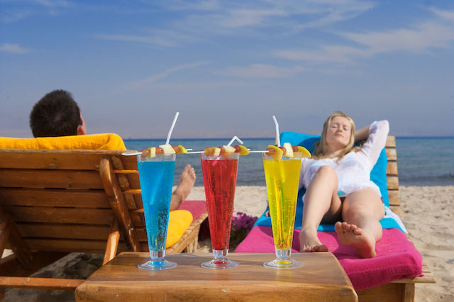 A couple relaxes by the beach of Sinai Bay with served refreshing drinks at Taba Heights
