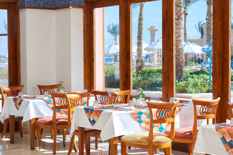 The colorful and wooden decor of the Mediterranean restaurant at Mosaique Beach Resort in Taba Heights